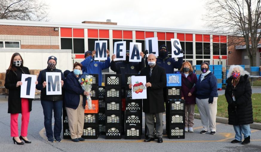 ϲʿapp Meal Distribution team celebrates 1 Million Meals with signs and a group photo.